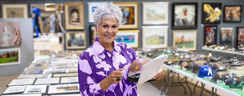 Woman with short gray hair looking at items in a silent auction